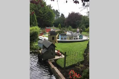 a toy house on the side of a river with a boat at Langan's Blackpool Holiday Let in Blackpool