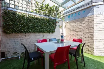 a table and chairs in a patio with a brick wall at Langan's Blackpool Holiday Let in Blackpool