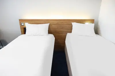 two beds in a room with white pillows at GO2 Lancaster Centre Hotel by OYO in Lancaster
