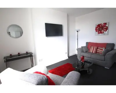 a living room with a couch and a tv at Coast Accommodation Station Road Apartments in Blackpool