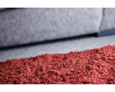 a close up of a red rug on the floor at Coast Accommodation Station Road Apartments in Blackpool