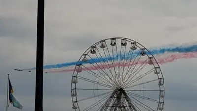 a ferris wheel with colored smoke in the sky at Coast Accommodation Station Road Apartments in Blackpool