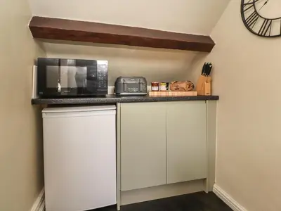 a kitchen with a counter with a microwave and a refrigerator at 25 St Georges Quay in Lancaster