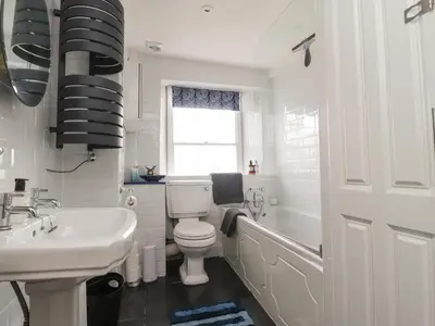a white bathroom with a toilet and a sink at 25 St Georges Quay in Lancaster