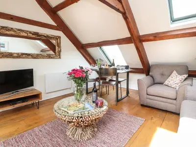 a living room with a table and a tv at 25 St Georges Quay in Lancaster