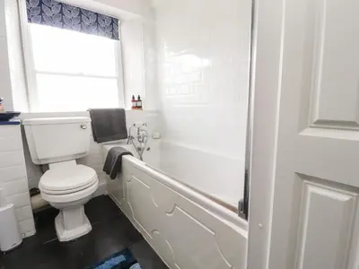 a bathroom with a toilet and a tub and a window at 25 St Georges Quay in Lancaster