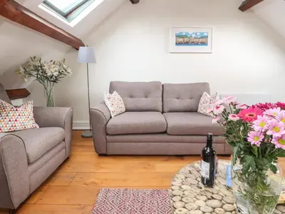 a living room with a couch and a table with flowers at 25 St Georges Quay in Lancaster