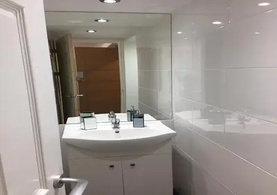 a white bathroom with a sink and a mirror at The Beaucliffe Hotel in Blackpool