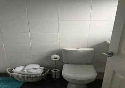 a bathroom with a toilet and a basket of towels at The Beaucliffe Hotel in Blackpool