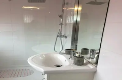 a white bathroom with a sink and a shower at The Beaucliffe Hotel in Blackpool