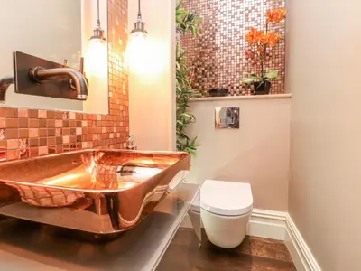 a bathroom with a copper sink and a toilet at Westwood House in Lytham St Annes