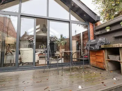 a patio with windows and chairs on a deck at Westwood House in Lytham St Annes