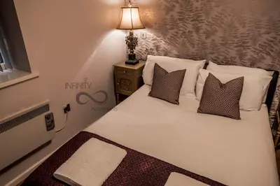 a bedroom with a white bed with pillows and a lamp at Contractor Bookers Liverpool City Centre in Liverpool