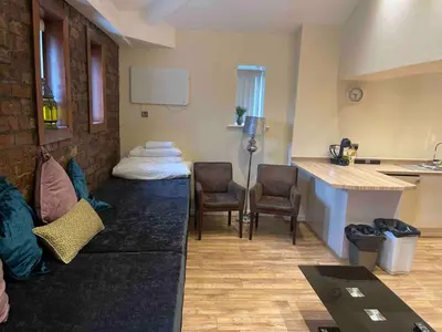 a living room with a couch and chairs and a kitchen at Contractor Bookers Liverpool City Centre in Liverpool