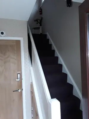 a stair case with black stairs and a door at Levens Terrace, Barrow Spa Therapy in Barrow in Furness