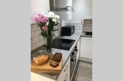 a kitchen with a vase of flowers on a counter at Dove Nest Cottage Blackpool Lytham St Annes in Lytham St Annes