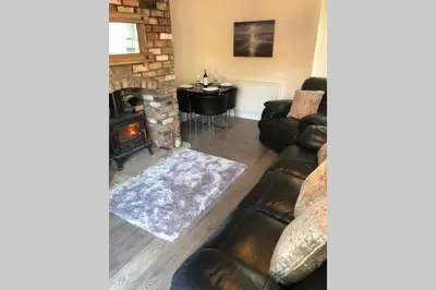 a living room with a couch and a fireplace at Dove Nest Cottage Blackpool Lytham St Annes in Lytham St Annes