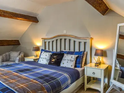 a bedroom with a bed and two night stands at Beeswax Cottage in Dalton in Furness