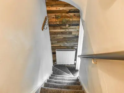 a stairway with a wooden wall and a stair case at Beeswax Cottage in Dalton in Furness