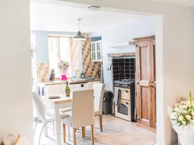 a kitchen and dining room with a table and chairs at Beeswax Cottage in Dalton in Furness