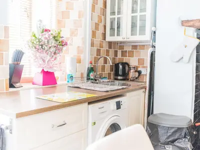 a kitchen with a sink and a washing machine at Beeswax Cottage in Dalton in Furness
