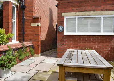 a wooden bench sitting in front of a brick building at Beachcomber Corner in Lytham St Annes