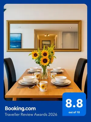 a table with a vase of sunflowers on it at Sidemersey Livings- Convenient and Central 2-Bedroom Haven in L1, Secured Parking in Liverpool