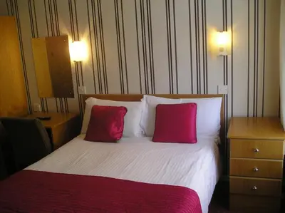 a hotel room with a bed with two pink pillows at The Belvedere in Blackpool