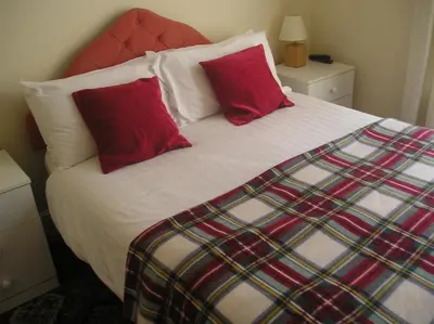 a bed with two red pillows on top of it at The Belvedere in Blackpool