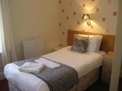 a bedroom with a bed with two towels on it at The Belvedere in Blackpool
