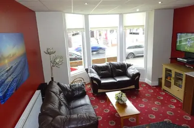 a living room with two leather couches and a television at The Belvedere in Blackpool
