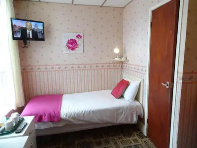 a bedroom with a bed with a tv on the wall at The Belvedere in Blackpool
