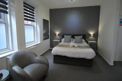 a bedroom with a bed and a chair in it at Hotel 33 in Blackpool