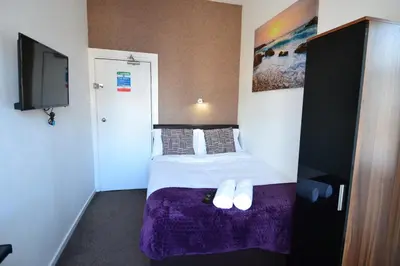 a hotel room with a bed with a purple blanket at Hotel 33 in Blackpool