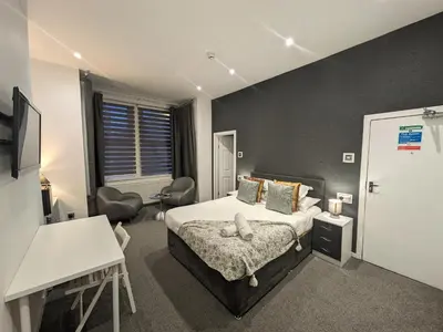 a bedroom with a bed and a desk and a table at Hotel 33 in Blackpool