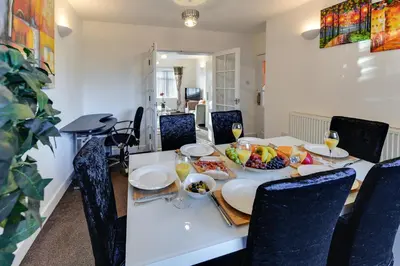 a dining room table with fruits and plates on it at 3 BR Home l Free Parking l 5 Guests l Garden l Long Stays l in Wigan