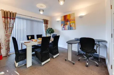a dining room with a table and chairs at 3 BR Home l Free Parking l 5 Guests l Garden l Long Stays l in Wigan