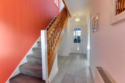 a staircase in a home with a red wall at 3 BR Home l Free Parking l 5 Guests l Garden l Long Stays l in Wigan