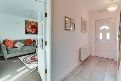 a living room with a couch and a door at 3 BR Home l Free Parking l 5 Guests l Garden l Long Stays l in Wigan
