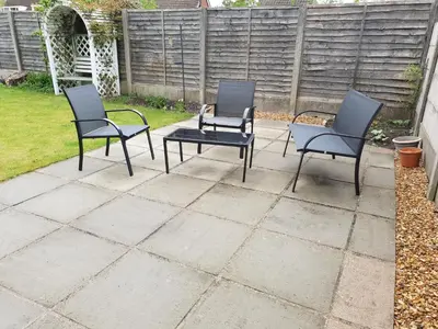 three chairs and a table on a patio at 3 BR Home l Free Parking l 5 Guests l Garden l Long Stays l in Wigan