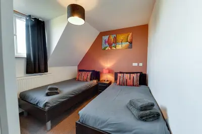 a bedroom with two beds and a window at 3 BR Home l Free Parking l 5 Guests l Garden l Long Stays l in Wigan