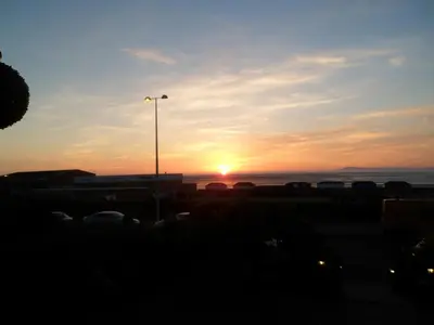 a sunset over a parking lot with a street light at Wavecrest Lodge in Fleetwood