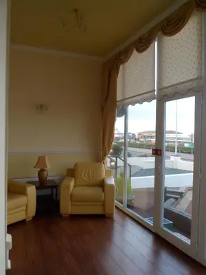 a living room with two chairs and a sliding glass door at Wavecrest Lodge in Fleetwood
