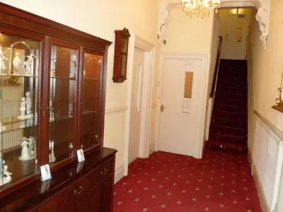a hallway with a chandelier and a staircase in a building at Wavecrest Lodge in Fleetwood