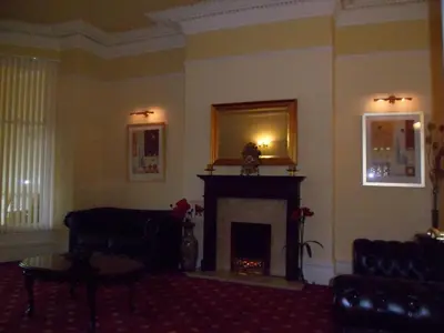 a living room with a fireplace and a mirror at Wavecrest Lodge in Fleetwood