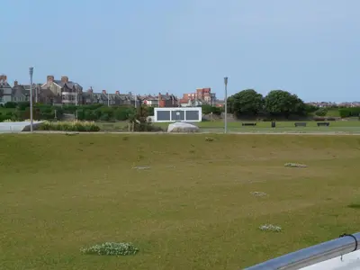a field of grass with buildings in the background at Wavecrest Lodge in Fleetwood