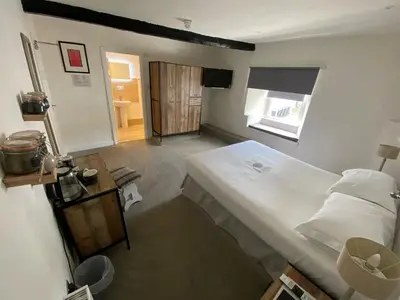 a bedroom with a large bed and a window at The Cavendish Arms in Cartmel