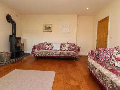 a living room with a couch and a fireplace at Hill Brook Barn in Clitheroe