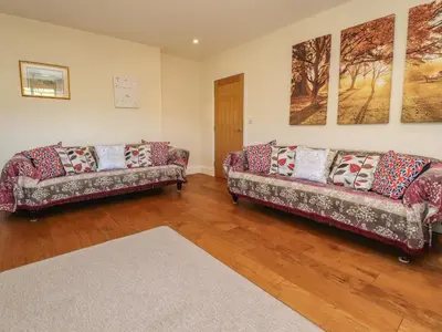 a living room with two couches and a rug at Hill Brook Barn in Clitheroe
