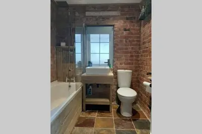 a bathroom with a toilet and a tub and a sink at Unique 2 Bedroom Apartment in the Ideal Location in Blackpool